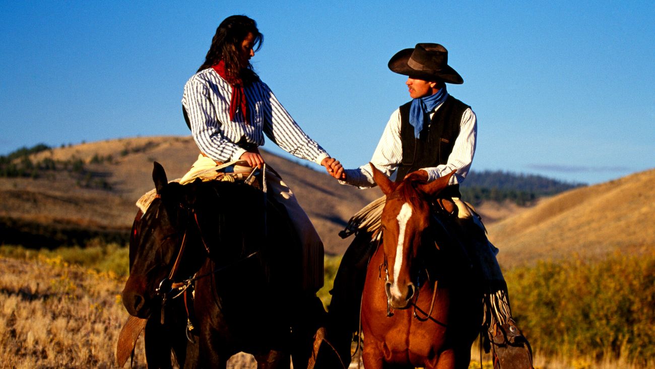 Couple cowboy sur des cheveaux 