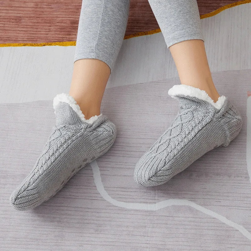 Getragene graue Thermosocken nebeneinander auf einem Teppich.