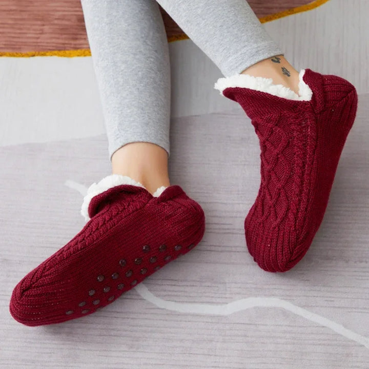 Getragene bordeauxrote Thermosocken mit sichtbaren Noppen unter dem Fuß.