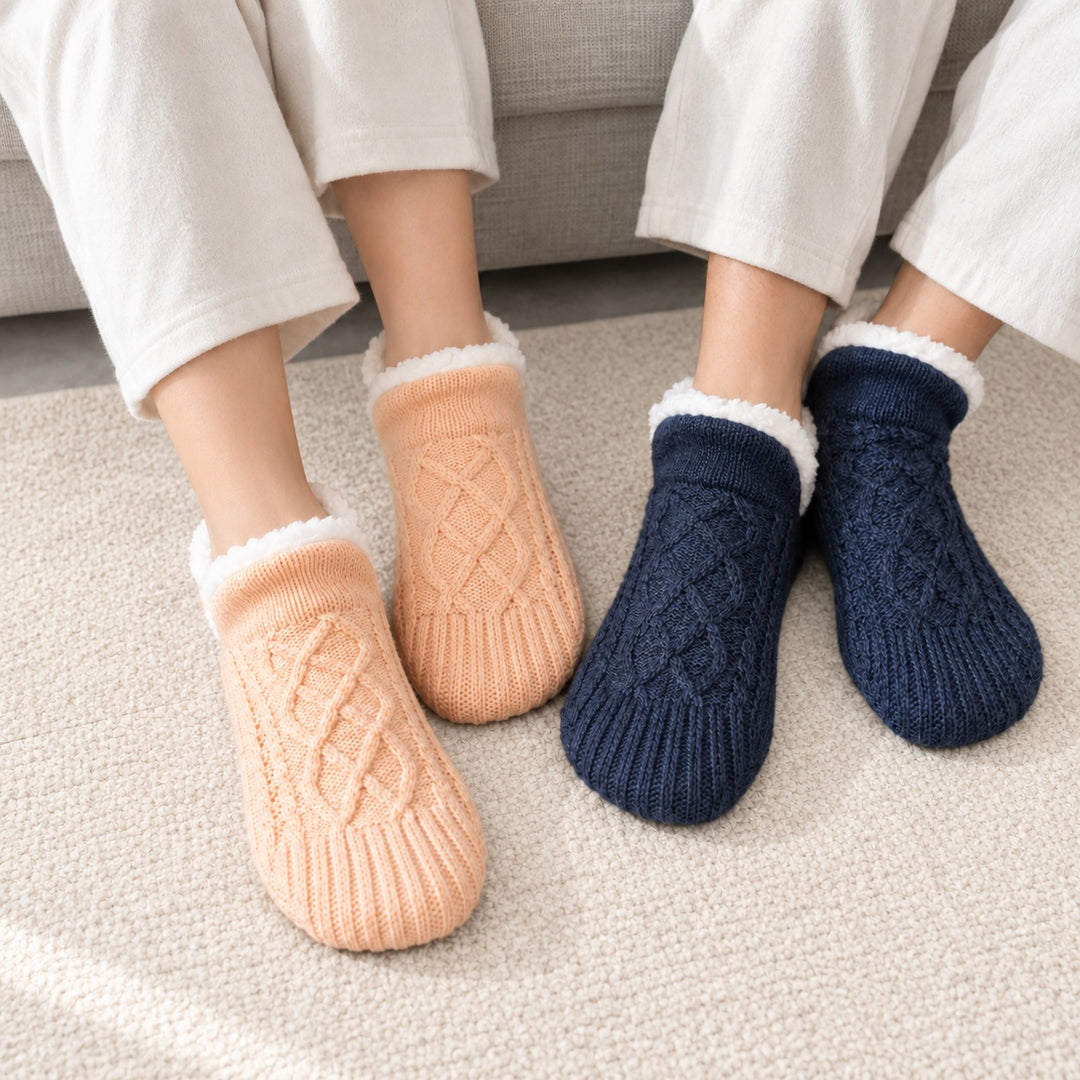 Paar mit Thermosocken in Apricot und Marineblau auf einem cremefarbenen Teppich.