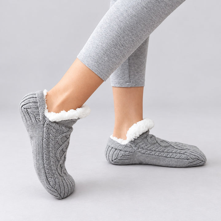 Graue Thermosocken in getragener Seitenansicht mit flexibler Form vor hellgrauem Hintergrund.