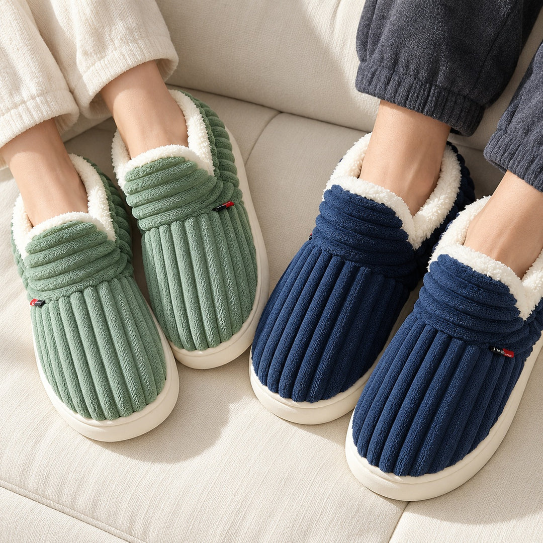 Chaussons verts et bleu marine portés à deux sur un canapé, vus du dessus