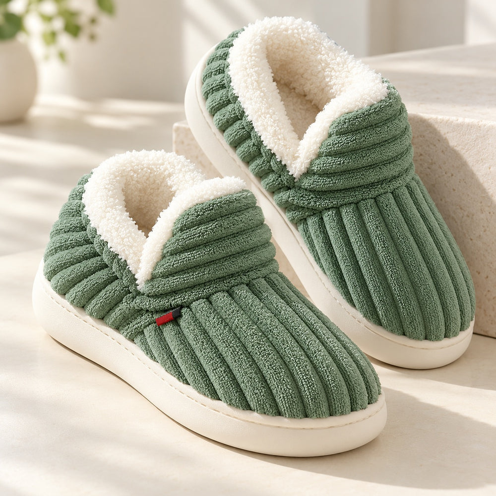 Paire de chaussons verts côtelés vue de trois quarts, avec doublure claire visible