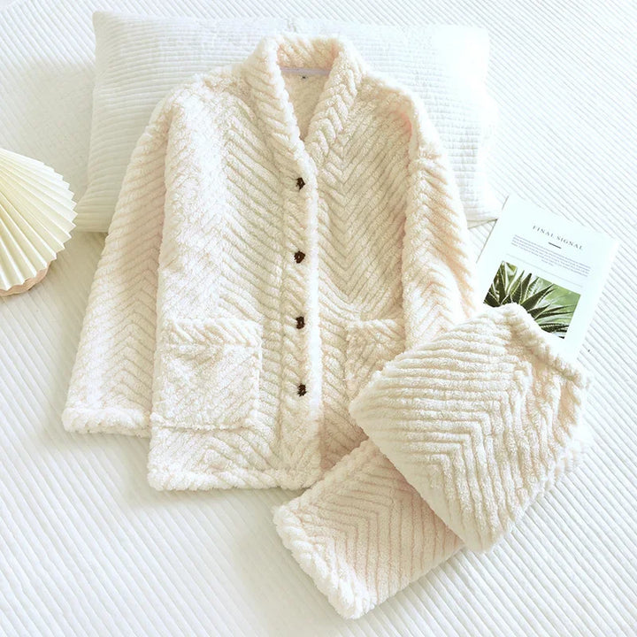 Ensemble pyjama blanc à chevrons, avec haut boutonné à col châle et pantalon assorti plié.