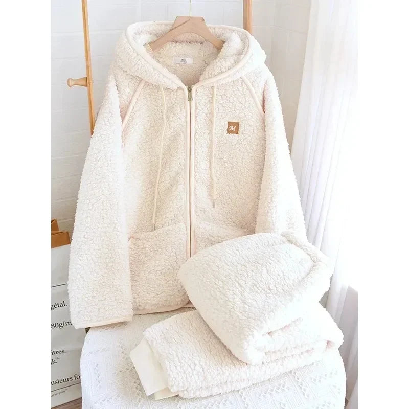 Pyjama-Set in Ecruweiß mit Kapuzenjacke am Bügel und gefalteter passender Hose.