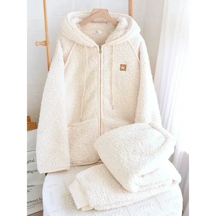 Pyjama-Set in Ecruweiß mit Kapuzenjacke am Bügel und gefalteter passender Hose.