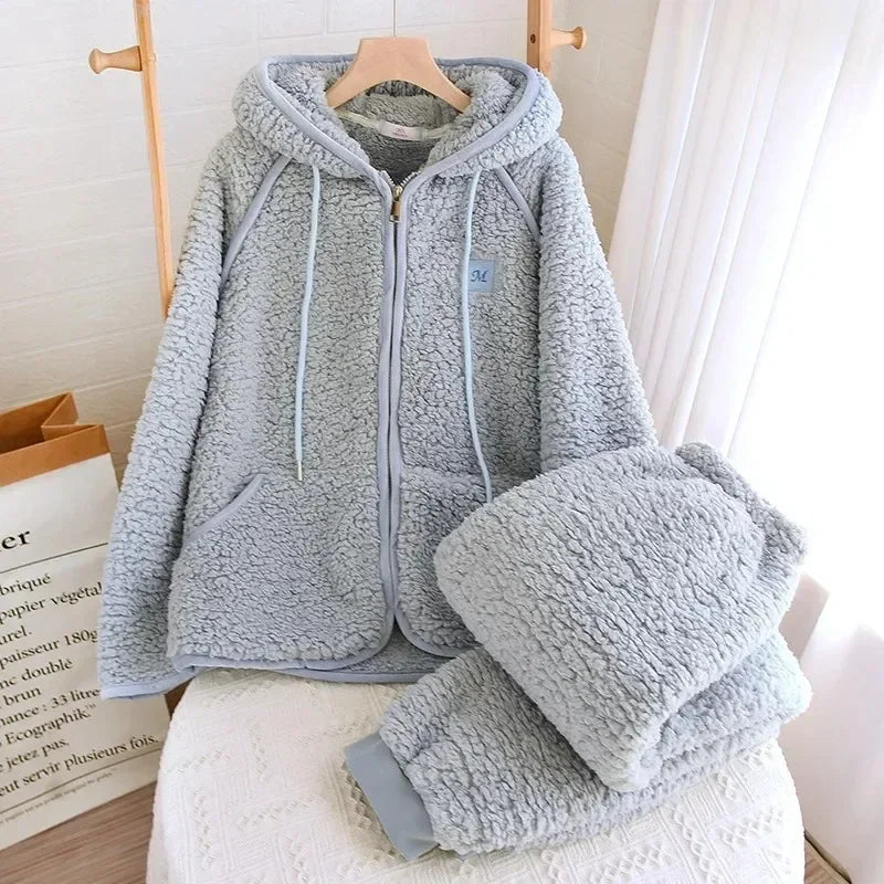 Pyjama-Set in Graublau mit Kapuzenjacke am Bügel und gefalteter passender Hose.