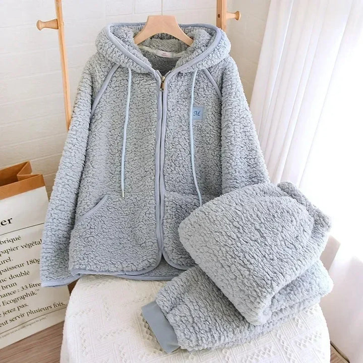 Pyjama-Set in Graublau mit Kapuzenjacke am Bügel und gefalteter passender Hose.