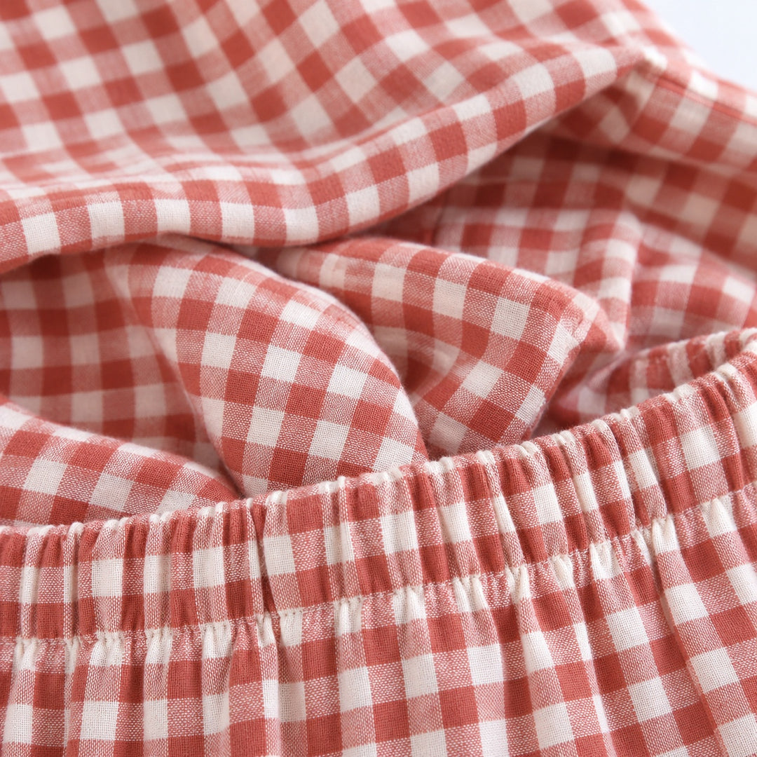 Gros plan sur la taille élastiquée du pantalon de pyjama à carreaux corail.