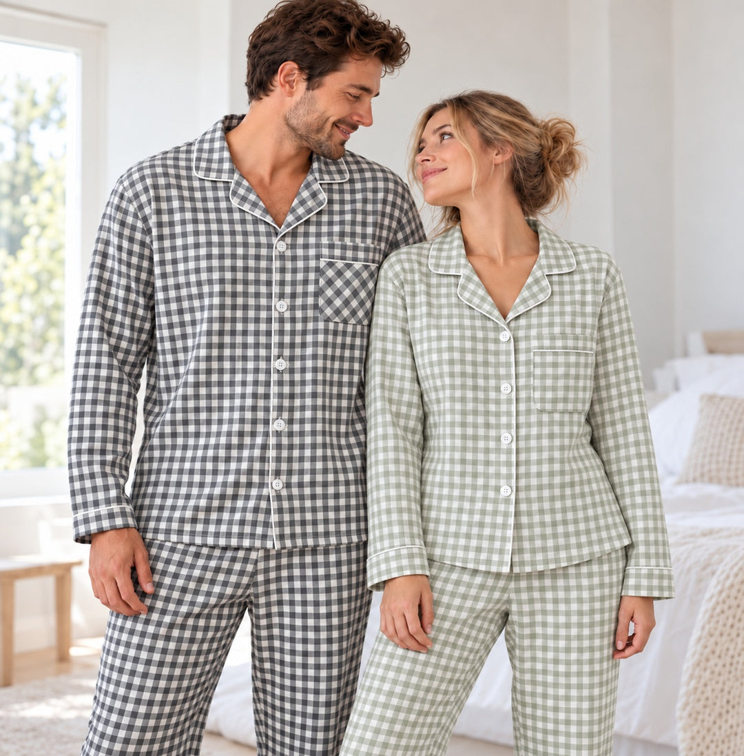 Couple portant les pyjamas à carreaux vert sauge et gris, cadré de la tête aux cuisses dans une chambre lumineuse.