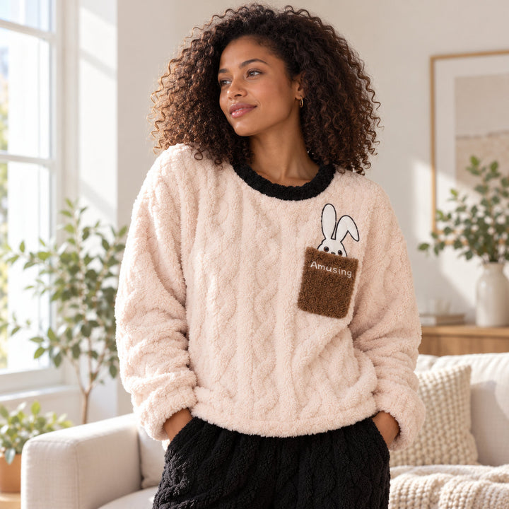 Femme portant le pyjama couple hiver, haut clair à poche lapin et pantalon noir