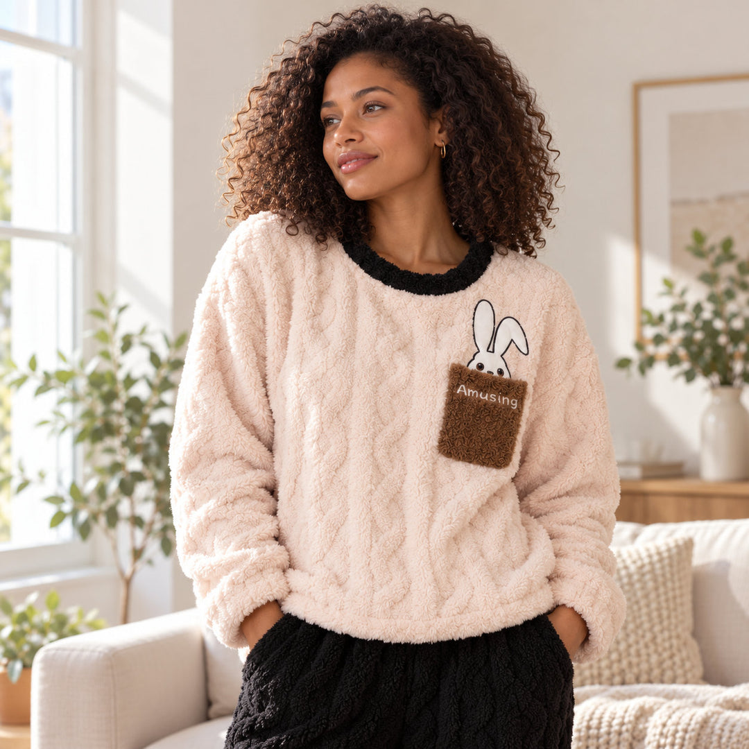 Femme portant le pyjama couple hiver, haut clair à poche lapin et pantalon noir