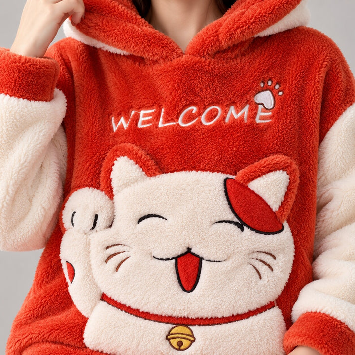 Gros plan du motif chat souriant, grelot, inscription Welcome et texture rouge