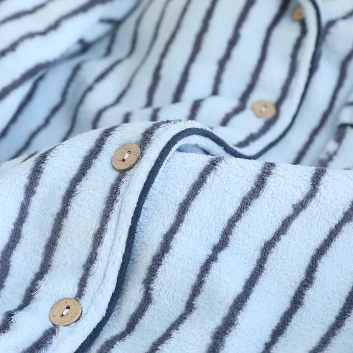 Detail der hellen Knöpfe und der Verarbeitung des blau gestreiften Pyjamaoberteils