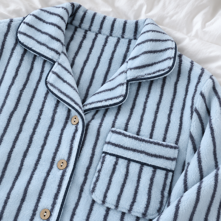 Nahaufnahme von Kragen, Knöpfen und Brusttasche des blau gestreiften Pyjamas