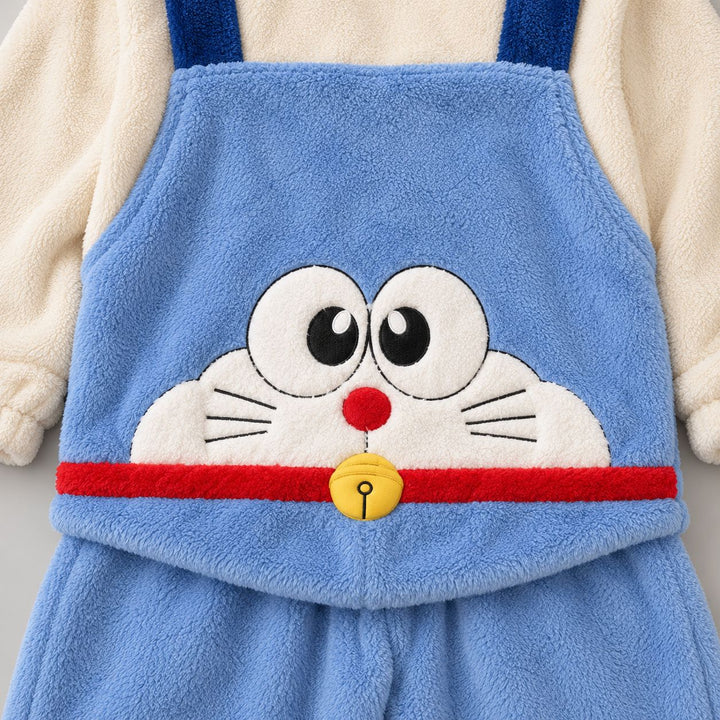 Gros plan du personnage chat sur le devant du Pyjama Duo bleu, yeux, moustaches, bande rouge et grelot jaune