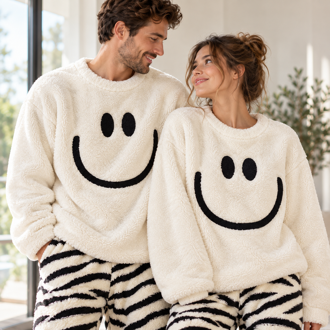 Couple portant le pyjama duo pilou pilou blanc avec haut smiley et pantalon rayé noir