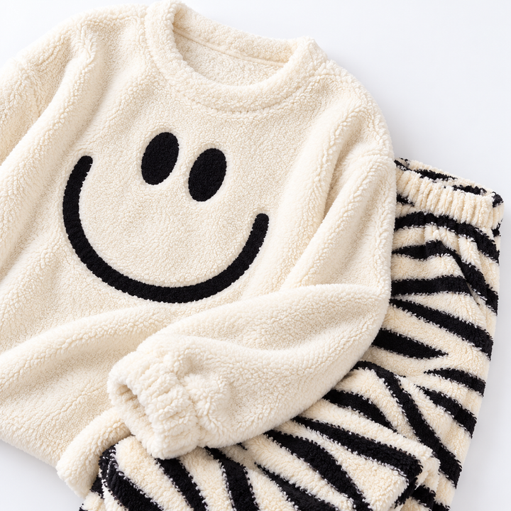 Gros plan flatlay du pyjama duo couple en tissu pilou avec motif sourire et rayures