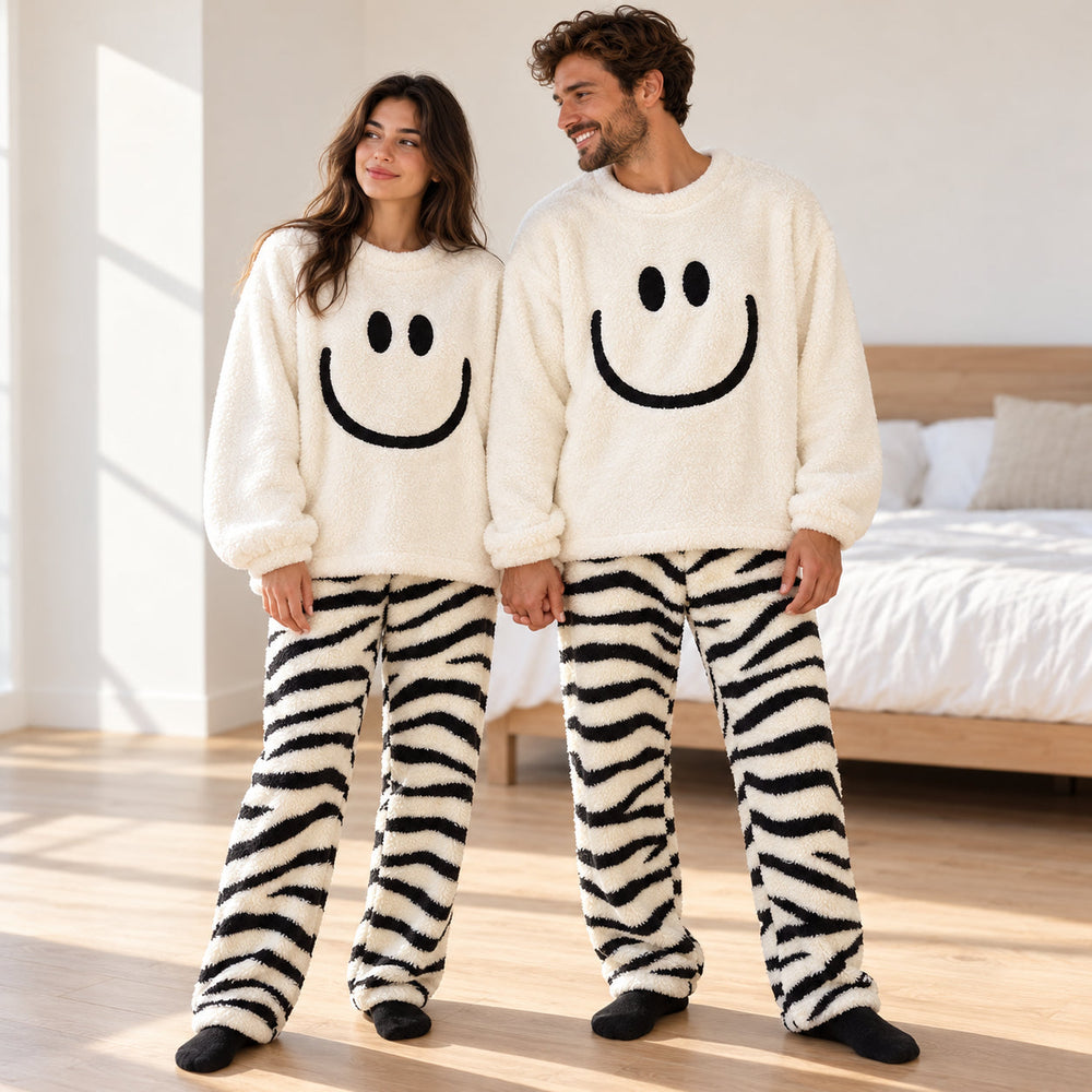 Partnerlook-Pyjama in Ganzkörperansicht mit weißem Smiley-Oberteil und schwarz gestreifter Plüschhose