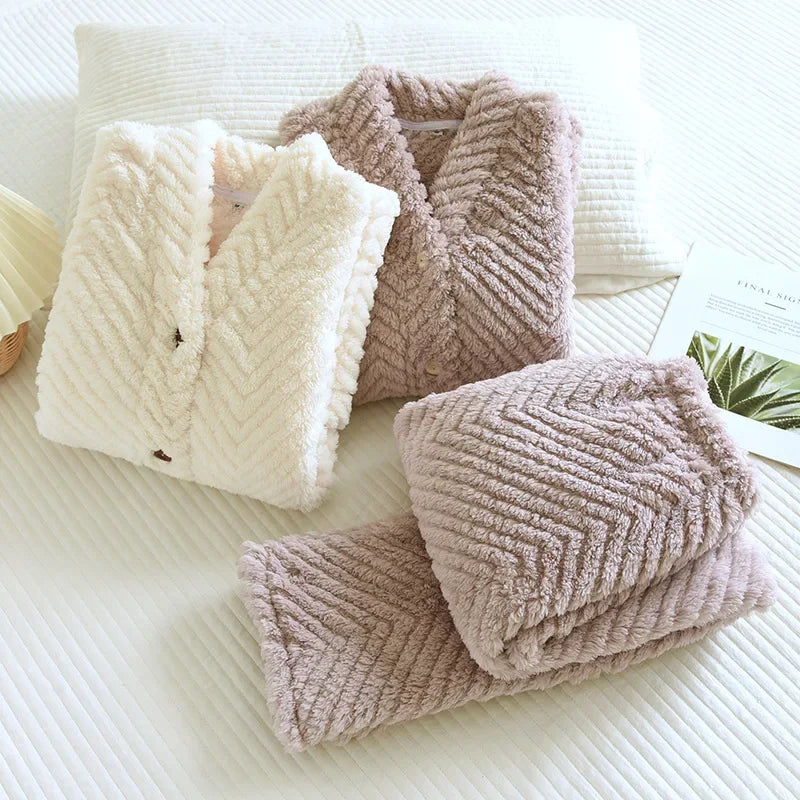 Pyjamas blanc et violet pliés, montrant les cols châles, les boutons et le relief en chevrons.
