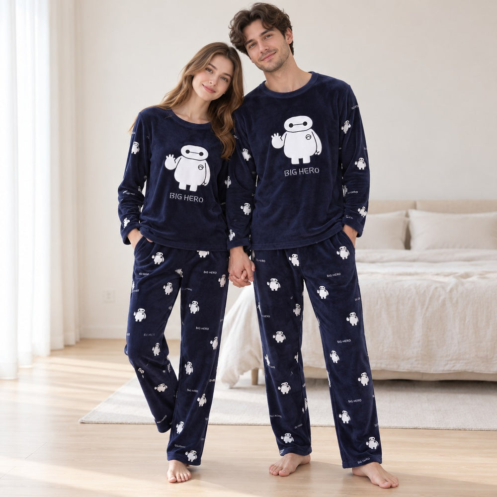 Couple debout en pyjamas bleu marine assortis à motif robot blanc, tenues complètes