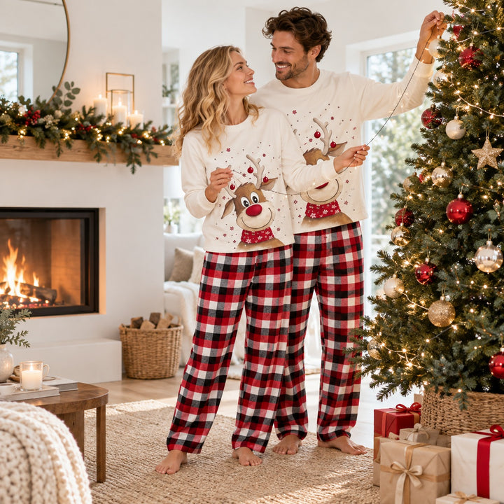 Couple en pyjama Noël assorti décorant le sapin