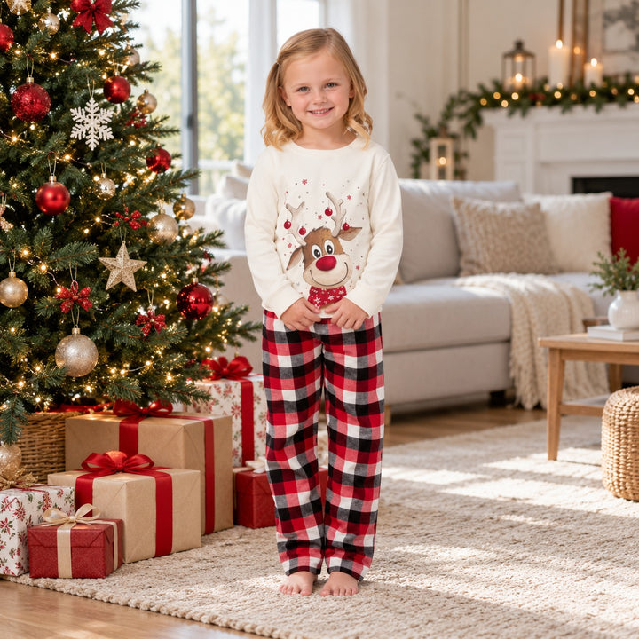 Fille portant le pyjama Noël assorti près du sapin