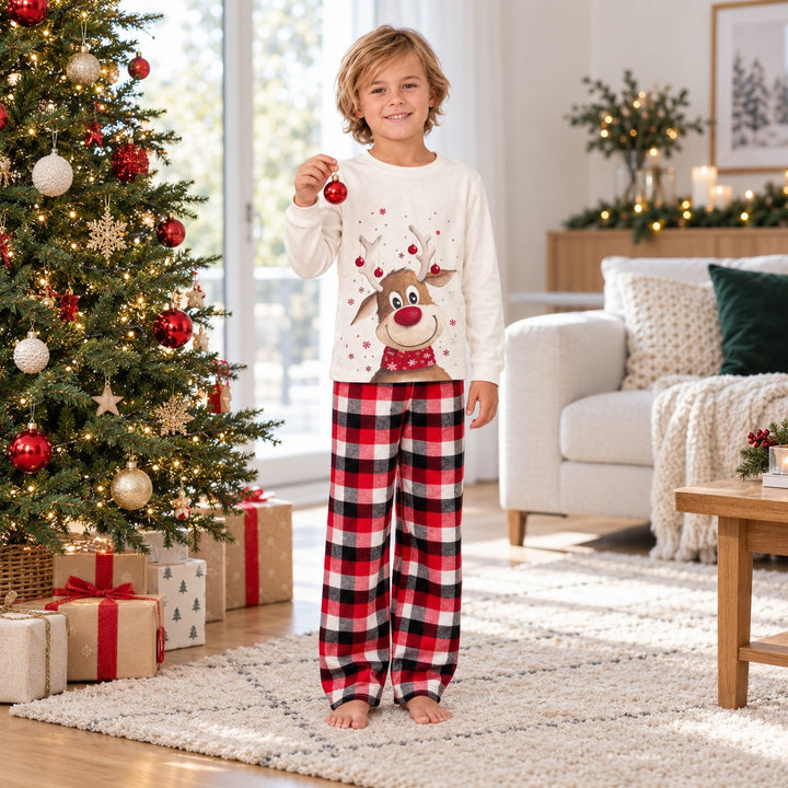 Garçon portant le pyjama Noël assorti près du sapin