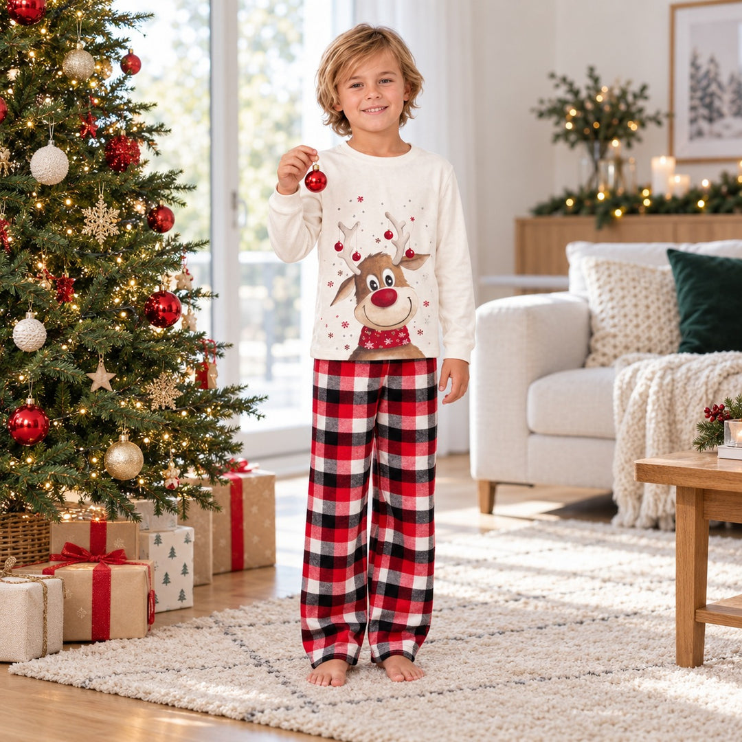 Garçon portant le pyjama Noël assorti près du sapin