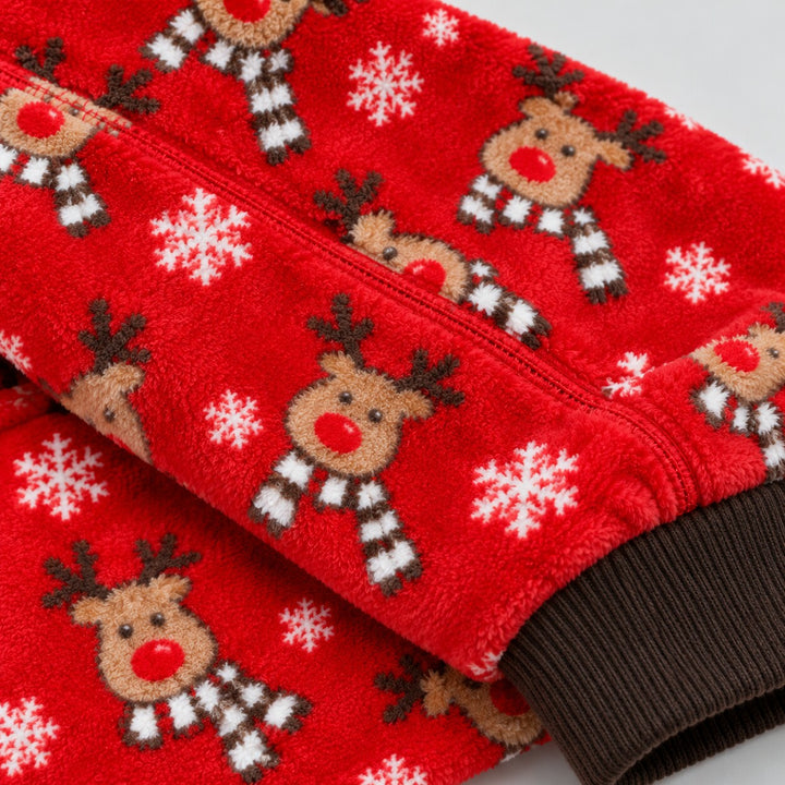 Gros plan de la texture rouge et des motifs rennes et flocons du pyjama de Noël
