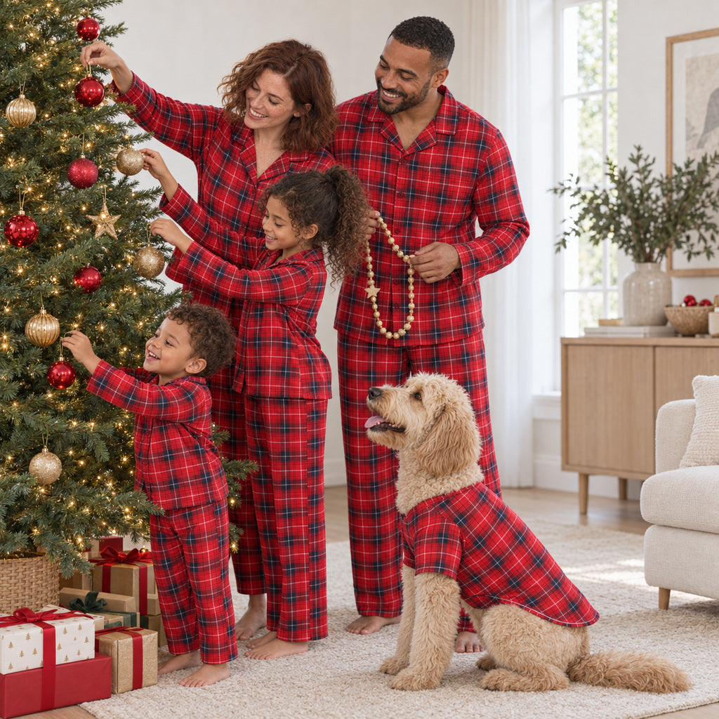 Famille et chien en pyjamas de Noël assortis décorant le sapin