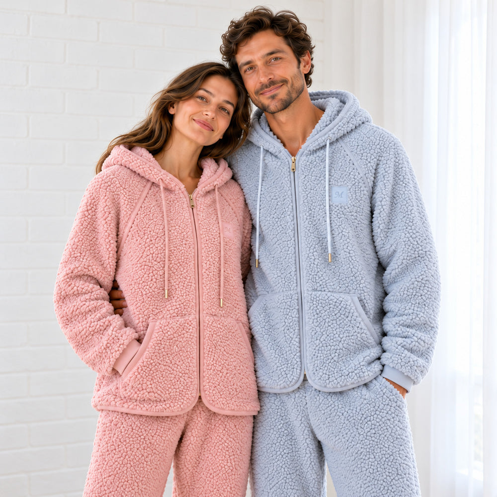 Paar in Kapuzenpyjamas in Altrosa und Graublau, Nahaufnahme der Jacken mit Reißverschluss.