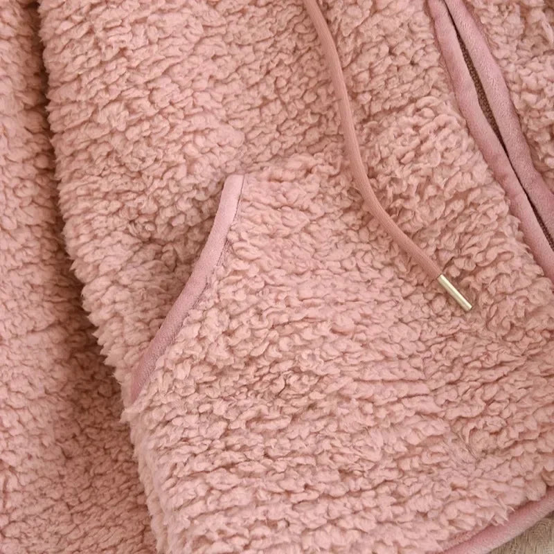 Detail der abgerundeten Vordertasche, Kordeln und des Reißverschlusses der Pyjamajacke in Altrosa.