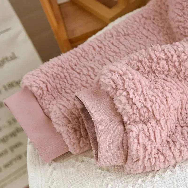 Detail der glatten Ärmelbündchen und der lockigen Struktur des Pyjamas in Altrosa.