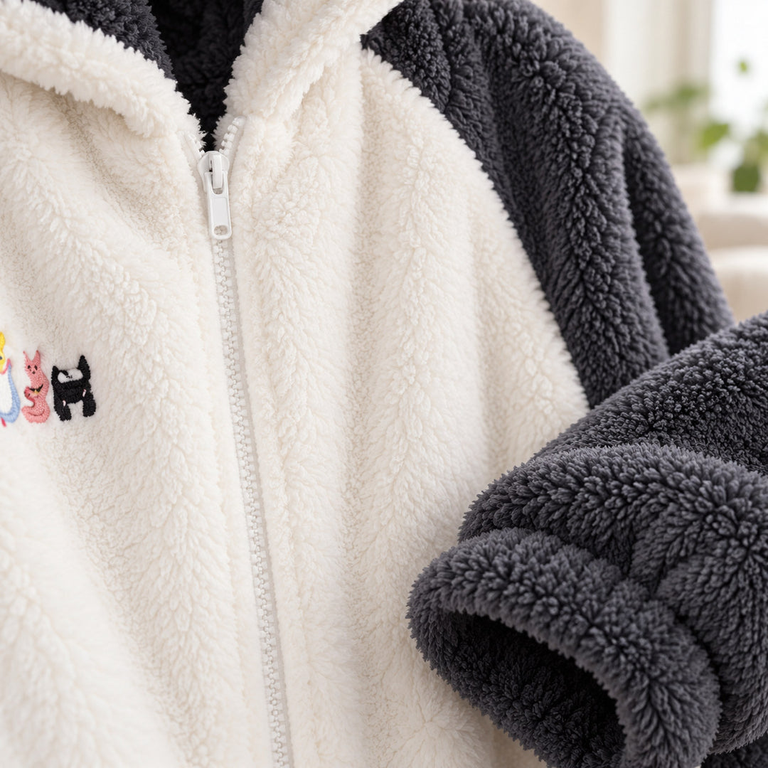 Gros plan sur le zip et la texture gris foncé et écru du pyjama rigolo couple